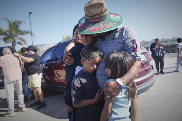 (People embrace outside of Glass House Farms, a day after an immigration raid on the facility, on Friday, July 11, 2025, in Camarillo, Calif. (AP Photo: Damian Dovarganes)