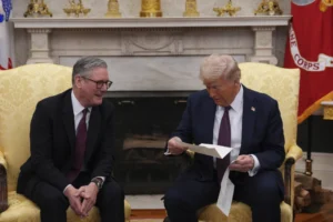 (British Prime Minister Keir Starmer, left, hands an invitation from King Charles III for a second state visit to President Donald Trump at the White House, Thursday, Feb. 27, 2025, in Washington. (Carl Court/Pool via AP, File)