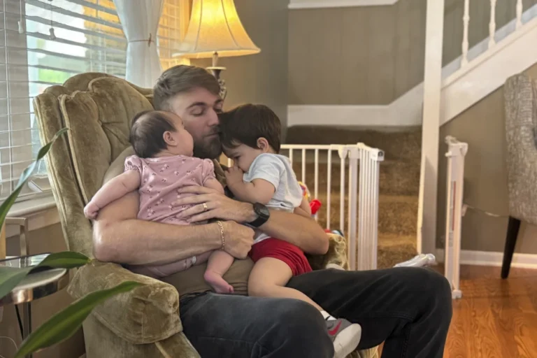 U.S. Marine Corps veteran Adrian Clouatre holds his 3-month-old daughter Lyn and his nearly two old son Noah at their home in Baton Rouge, La., June 17, 2025. (AP Photo/Stephen Smith, File)
