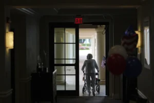 A woman uses a walker as she exits an assisted living building at the Toby and Leon Cooperman Sinai Residence, July 4, 205, Boca Raton Fla. AP Photo: Rebecca Blackwell)