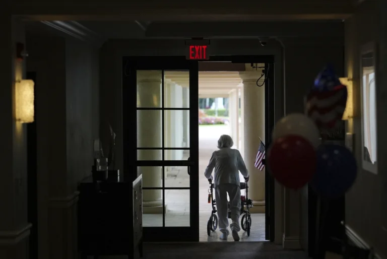 A woman uses a walker as she exits an assisted living building at the Toby and Leon Cooperman Sinai Residence, July 4, 205, Boca Raton Fla. AP Photo: Rebecca Blackwell)