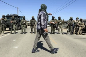  A confrontation erupted Thursday between protesters and federal officials carrying out a raid on a Southern California farm, with authorities throwing canisters that sprayed what looked like smoke into the air to disperse the crowd.