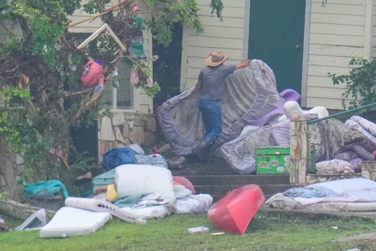 (A person removes bedding from sleeping quarters at Camp Mystic along the banks of the Guadalupe River after a flash flood swept through the area Sunday, July 6, 2025, in Hunt, Texas. (AP Photo: Julio Cortez)