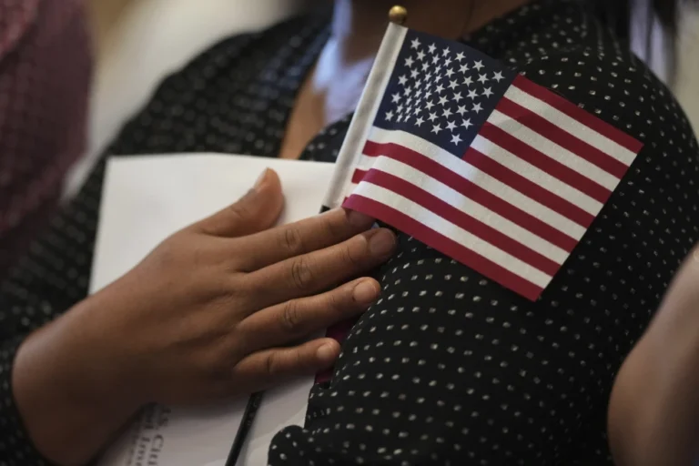 (A woman clutches a U.S. flag as she and applicants from other countries prepare to take the oath of citizenship in commemoration of Independence Day during a Naturalization Ceremony in San Antonio, July 3, 2025. AP Photo: Eric Gay, File)