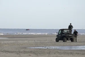 Gendarmes watch migrants on a small boat from Ecault beach, Friday July 4, 2025. (AP photo/John Leicester, File)