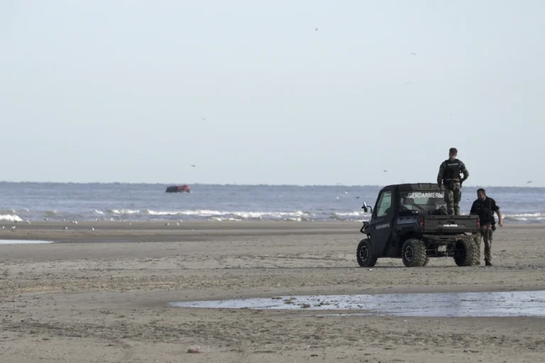 Gendarmes watch migrants on a small boat from Ecault beach, Friday July 4, 2025. (AP photo/John Leicester, File)