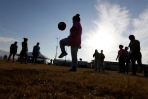 Immigrants play soccer at a new U.S. government holding center for migrant children in Carrizo Springs, Texas, July 9, 2019. (AP Photo/Eric Gay, File)