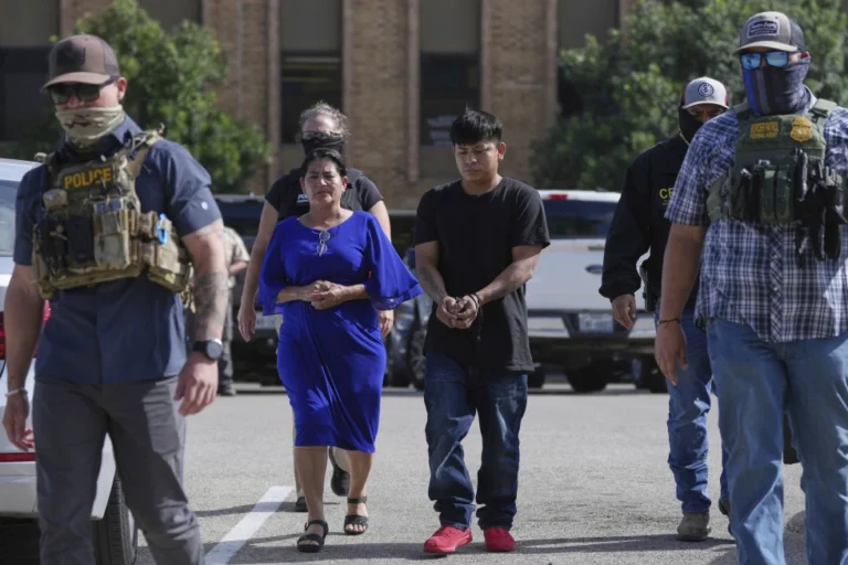 Federal agents escort a family to a transport bus after they were detained following an appearance at immigration court, July 22, 2025, in San Antonio, Texas. (AP Photo/Eric Gay, File)