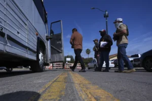 (Federal agents escort a man to a transport bus after he was detained following an appearance at immigration court, Tuesday, July 22, 2025, in San Antonio. (AP Photo/Eric Gay)