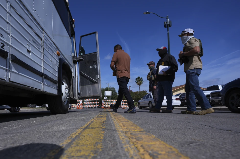 (Federal agents escort a man to a transport bus after he was detained following an appearance at immigration court, Tuesday, July 22, 2025, in San Antonio. (AP Photo/Eric Gay)
