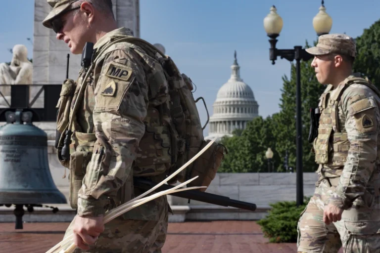 (National Guard personnel keep watch as travelers arrive at the entrance to Union Station near the Capitol in Washington, Thursday, Aug. 14, 2025. (AP Photo: J. Scott Applewhite)