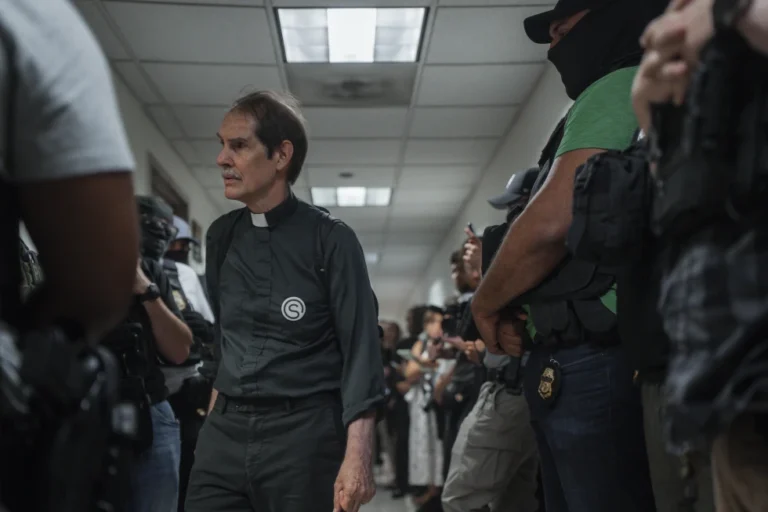 (A member of the clergy with New Sanctuary Coalition enters an immigration courtroom as federal agents wait outside on Tuesday, July 8, 2025, in New York.  AP Photo-Olga Fedorova)