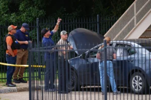 (A law enforcement agents search a vehicle near the scene of a shooting at a U.S. Immigration and Customs Enforcement office in Dallas on Wednesday, Sept. 24, 2025. AP Photo: Julio Cortez)