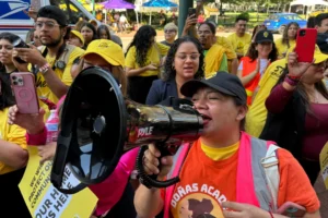 (DACA supporter Claudia Valdivia wields a megaphone at a rally outside federal appeals court in New Orleans on Thursday, Oct. 10 ,2024.  AP Photo: Jack Brook, File)