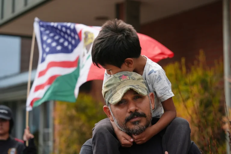 Gerardo Santos lifts his son Xavier during Protest