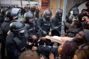 (Knowing that the eviction in the middle of winter was coming, most of the occupants had left to try to find other shelter before police in riot gear from Catalonia’s regional police entered the school’s premises early in the morning under court orders. While the eviction was completed without violence, there were moments of tension when people had to walk past armored officers.  AP Photo:  Emilio Morenatti)