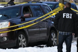 (A bullet hole is seen in the windshield as law enforcement officers work the scene of a shooting involving federal law enforcement agents, Wednesday, Jan. 7, 2026, in Minneapolis.  AP Photo: Tom Baker)