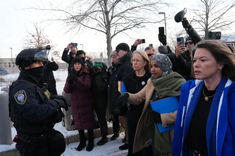 (Rep. Kelly Morrison D-Minn., center, Rep. Ilhan Omar, D-Minn., second from the right, and Rep. Angie Craig, D-Minn., far right, at the Bishop Whipple Federal Building, Saturday, Jan. 10, 2026, in Minneapolis. AP Photo: Adam Gray)
