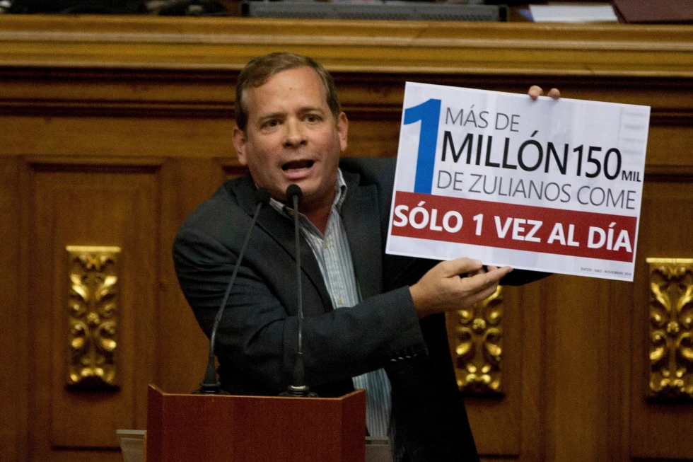 (Opposition lawmaker Juan Pablo Guanipa displays a sign that reads in Spanish “More than a million residents of Zulia State eat only once a day” during an intervention against Venezuela’s President Nicolas Maduro at National Assembly, in Caracas, Venezuela, Dec. 13, 2016.  AP Photo: Fernando Llano, File)