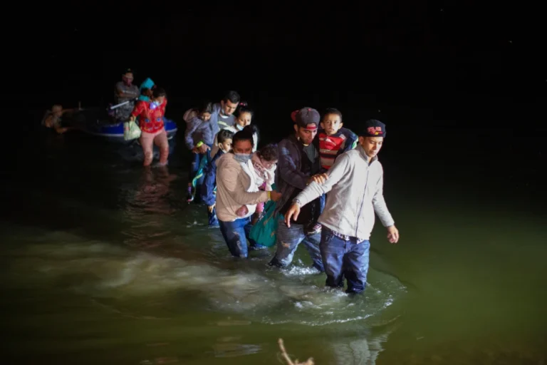 (Migrant families wade through shallow waters toward Roma, Texas, March 24, 2021.  AP Photo: Dario Lopez-Mills, File)