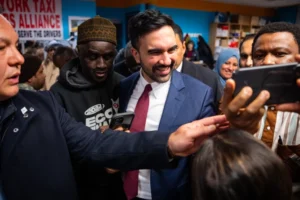 (People greet and take photos with New York City Mayor Zohran Mamdani at a Ramadan Iftar hosted by his team at the New York Taxi Workers Association, Wednesday, March 18, 2026, in New York.  AP Photo: Angelina Katsanis)