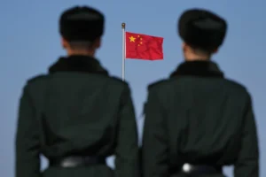 (Soldiers stand watch against the national flag on Tiananmen Square during a press conference ahead of the opening of the Chinese People’s Political Consultative Conference (CPPCC) held at the Great Hall of the People in Beijing, China, Tuesday, March 3, 2026.  AP Photo: Andy Wong)