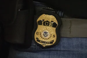(A federal agent wears an Immigration and Customs Enforcement badge in New York, June 10, 2025.  AP Photo: Yuki Iwamura, File)