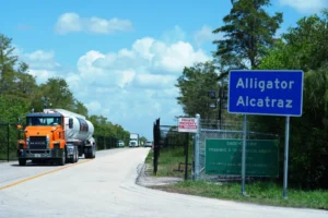 (Trucks come and go from the “Alligator Alcatraz” immigration detention center in the Florida Everglades, Thursday, Aug. 28, 2025, in Collier County, Fla. AP File Photo: Rebecca Blackwell)