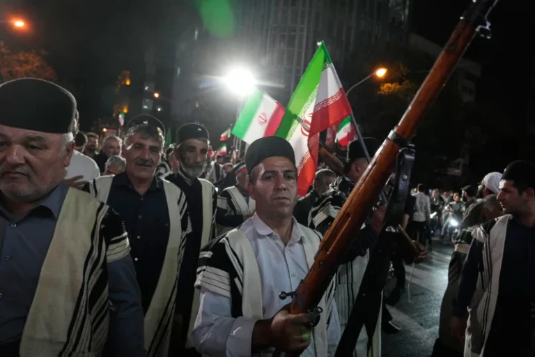 (Bakhtiari nomads, wearing traditional dress, chant slogans as one of them holds a gun during a pro-government gathering on Monday, May 18, 2026, near the residence where former Iranian Supreme Leader Ayatollah Ali Khamenei was killed in U.S. and Israeli strikes in Tehran, Iran. (AP Photo/Vahid Salemi)