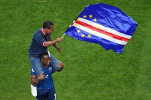 (Cape Verde head coach Bubista waves a flag while being carried on the shoulder of Jovane Cabral (7) during the World Cup Group H soccer match between Cape Verde and Saudi Arabia in Houston, Friday, June 26, 2026.  AP Photo: Eric Gay)