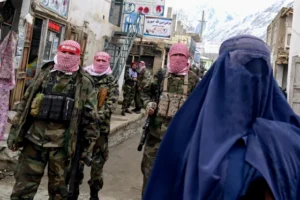 (File photo: Taliban fighters guard a burqa-clad woman as she walks on a street in Badakhshan province, Afghanistan, in 2024. Lawyer Kohsar-AFP)