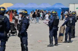 (Police conduct a search operation at a makeshift camp of migrants who want to cross the English Channel to Britain near Dunkirk, northern France, Wednesday, May 27, 2026.  AP Photo: Jean-Francois Badias)