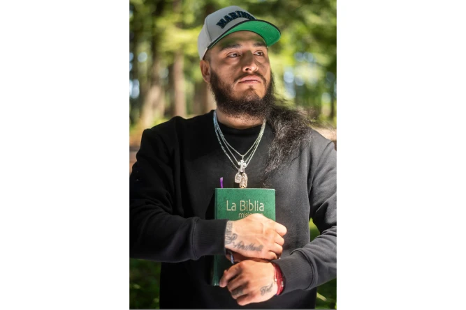(Gabriel Martinez Garcia, 30, holds a Bible close to his chest as tattoos of his parents are visible on his wrists, in Tenino, Wash., on Sunday, June 14, 2026. AP Photo: Akash Pamarthy)