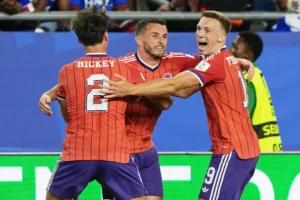 (Scotland’s John McGinn (7) celebrates with teammate’s Aaron Hickey (2) and Lewis Ferguson (19) after scoring his teams first goal during the World Cup Group C soccer match between Haiti and Scotland in Foxborough, Mass., near Boston,... AP Photo: Martin Meissner)