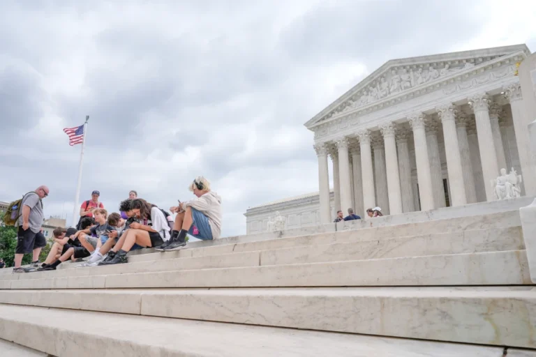 (Visitors sit on the steps of the U.S. Supreme Court, Monday, June 8, 2026, in Washington. (AP Photo/Mariam Zuhaib)