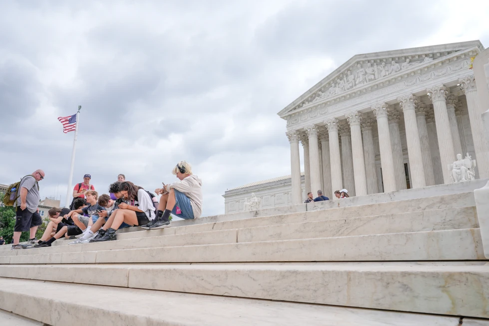 (Visitors sit on the steps of the U.S. Supreme Court, Monday, June 8, 2026, in Washington. (AP Photo/Mariam Zuhaib)