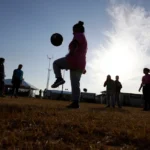 (Immigrants play soccer at a new U.S. government holding center for migrant children, in Carrizo Springs, Texas, July 9, 2019.  AP File Photo: Eric Gay)