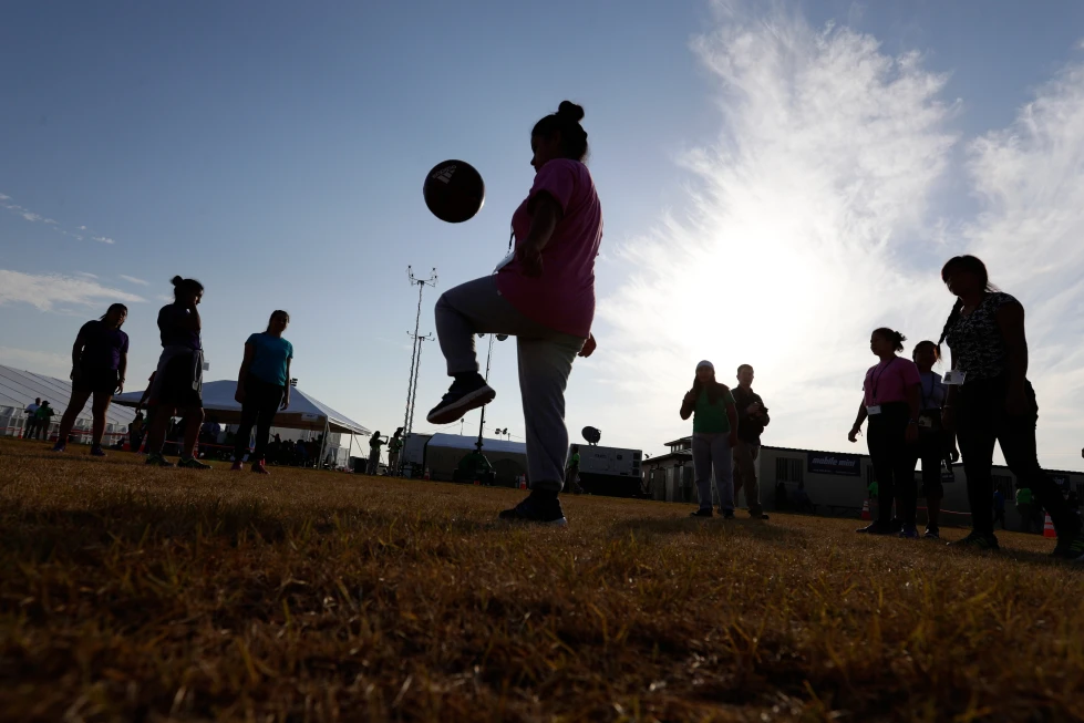 (Immigrants play soccer at a new U.S. government holding center for migrant children, in Carrizo Springs, Texas, July 9, 2019.  AP File Photo: Eric Gay)