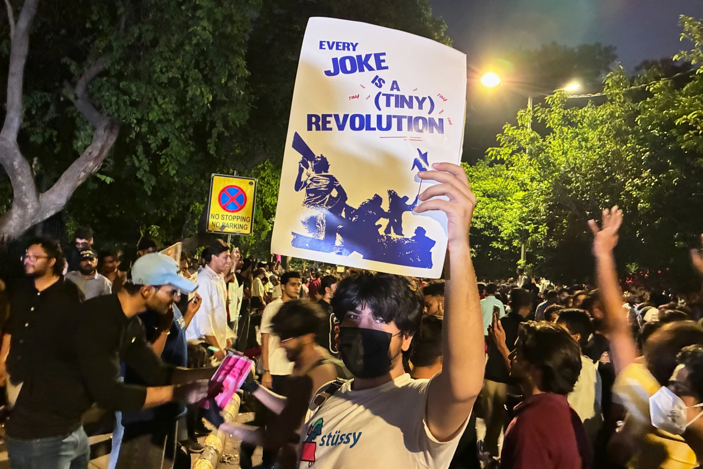 (A protestor holds a placard with the message "Every Joke is a Tiny Revolution" during a demonstration demanding educational reforms as part of the Cockroach Janta Party's ongoing protest movement in New Delhi, India, Thursday, July 23, 2026.  AP Photo: Verda Sabzwari)