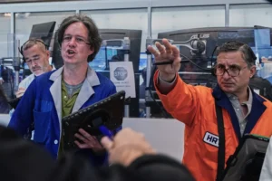 (Options traders Justin Kanda, Doran Swan, and Ravi Bhandari. left to right, work on the floor of the New York Stock Exchange, Thursday, June 25, 2026.  AP Photo: Richard Drew)