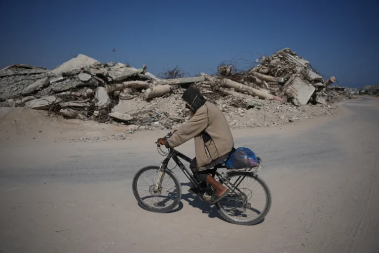 (A Palestinian man rides his bicycle by the rubble of buildings that were destroyed during the Israel Hamas war, in Khan Younis, southern Gaza Strip, Friday, July 31, 2026. AP Photo: Abdel Kareem Hana)