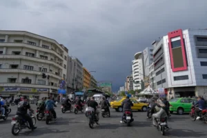(Motorbikes and cars pass through an intersection in downtown Tehran, Iran, May 17, 2026. (AP File Photo: Vahid Salemi)