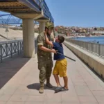 (A 12-year-old unaccompanied minor who crossed into Spain is escorted by a Spanish soldier to the Spain-Morocco border as the child begs not to be sent back to Morocco from the Spanish enclave of Ceuta, Monday, Aug. 3, 2026. The forced deportation of the unaccompanied minor was stopped by a high-ranking official a few yards before the child reached the border after residents and journalists said the migrant was a minor. AP Photo: Bernat Armangue)