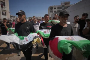(Mourners carry the flag-draped bodies of Palestinians killed in Israeli strikes during the war with Hamas, whose remains were recently recovered from the rubble, in Gaza City, Thursday, Aug. 20, 2026.  AP Photo: Jehad Alshrafi)