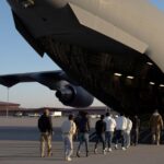 (US Customs and Border Protection security agents guide detained migrants to board a US Air Force aircraft in Texas. File Photo: Department of Defense/US Army Sgt. 1st Class Nicholas J De La Pena)