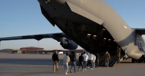 (US Customs and Border Protection security agents guide detained migrants to board a US Air Force aircraft in Texas. File Photo: Department of Defense/US Army Sgt. 1st Class Nicholas J De La Pena)