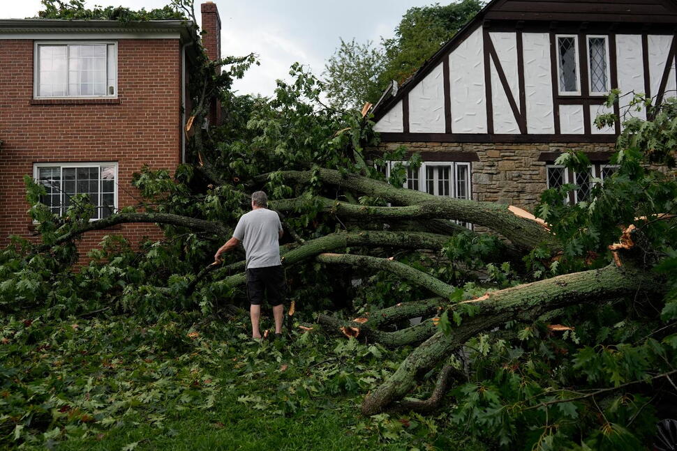 (A person inspects damage to homes from trees downed by severe storms on Tuesday, in Cincinnati on Wednesday, Aug. 12, 2026.  AP Photo: Carolyn Kaster)