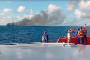 (In this image made from video released by the Indonesian National Search and Rescue Agency (BASARNAS), the crew of a rescue ship look on as smoke billows from a passenger ferry that caught fire while traveling from the tourist island of Bali to neighboring island of Lombok, in the waters of Lombok Strait, Indonesia, Wednesday, Aug. 12, 2026. (BASARNAS via AP)