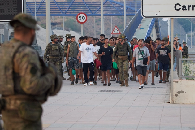 (Escorted by the Spanish army, migrants who crossed into Spain return to Morocco from the Spanish enclave of Ceuta on Aug. 1, 2026.  AP Photo: Antonio Sempere)