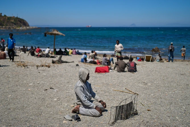 (A migrant who crossed into Spain from Morocco prays on a beach in the Spanish enclave of Ceuta, Sunday, Aug. 2, 2026.  AP Photo: Bernat Armangue)